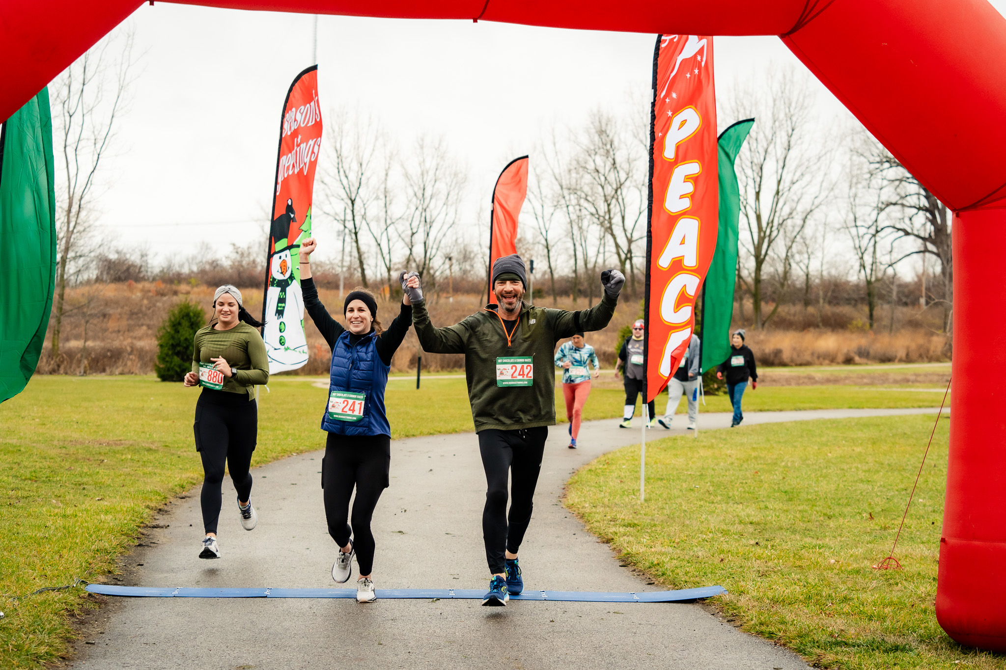Happy 5k and 10k Race Finishers Crossing The Finish Line - Hot Chocolate and Eggnog 1mi, 5k, 10k & Kids Dash - USA Race Timing and Event Management - Hot Chocolate 5k - Columbus Hot Chocolate Race - Amazing Swag - Great Finishers Medal - Mini Pies